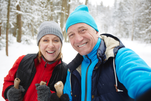 Older couple having fun in the woods during winter