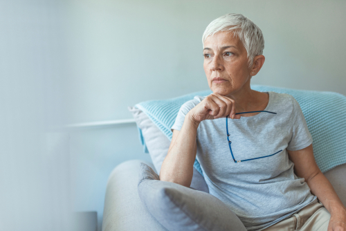 Older woman with cataracts holding eyeglasses