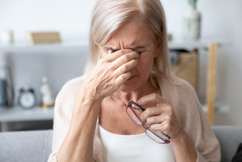 Older woman with cataracts rubbing her eyes