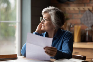 woman woman a desk reading a sheet of paper