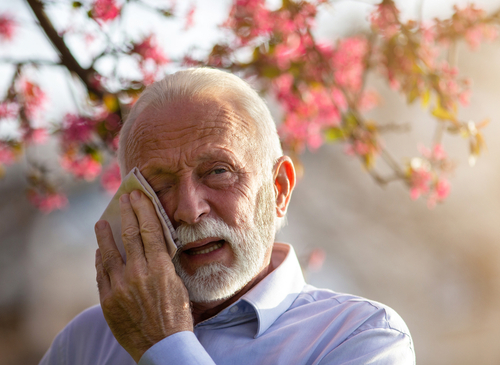 Man wiping his eyes