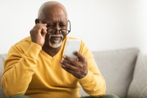 old man using glasses to read his phone