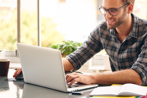 Man with eyeglasses looking at a computer