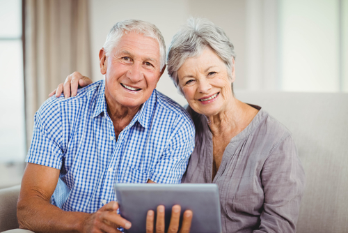 Smiling Older Couple Holding Tablet